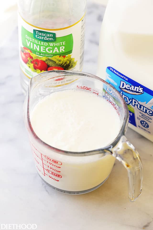 Milk combined with vinegar in a glass measuring cup.