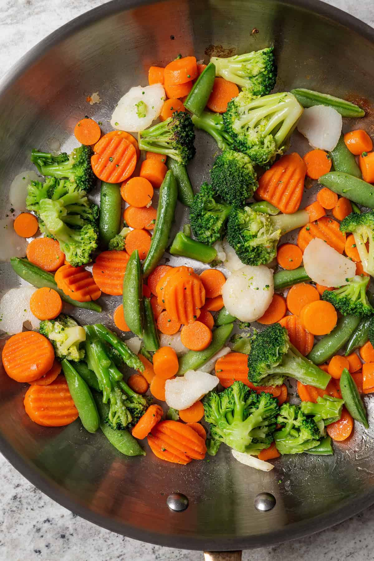 Stir fried vegetables in a metal skillet.