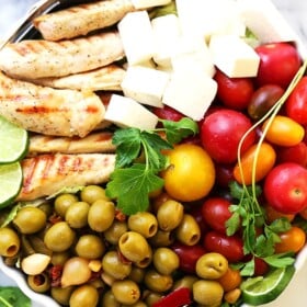 Lime Cumin Chicken Salad with Tomatoes, Olives and Queso Fresco - A huge bowl of flavor-packed, colorful, healthy chicken salad with tomatoes, fiesta blend olives and Mexican cheese.