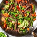 Ginger beef stir fry in a large metal skillet.