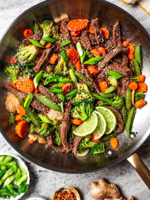 Ginger beef stir fry in a large metal skillet.