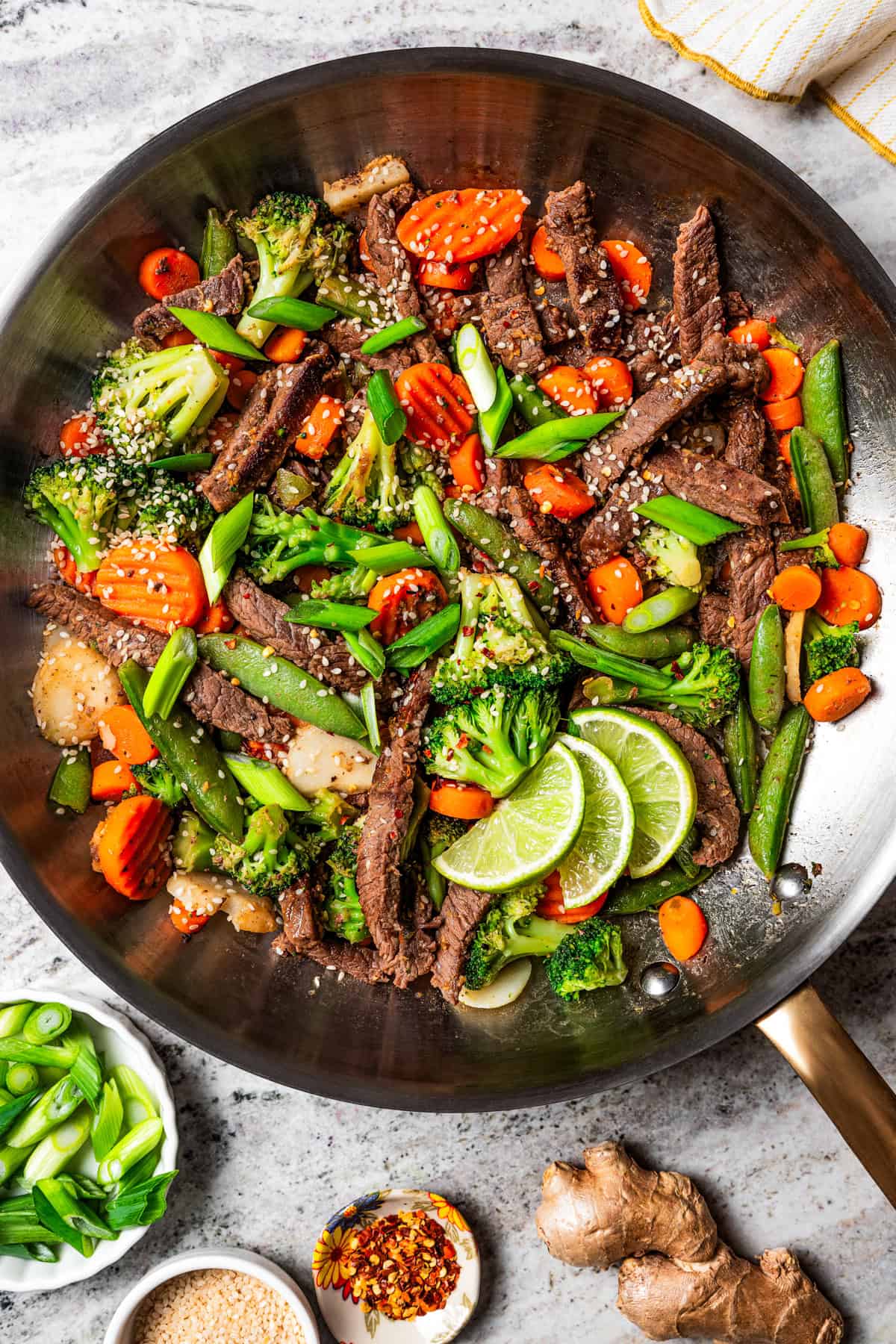 Ginger beef stir fry in a large metal skillet.