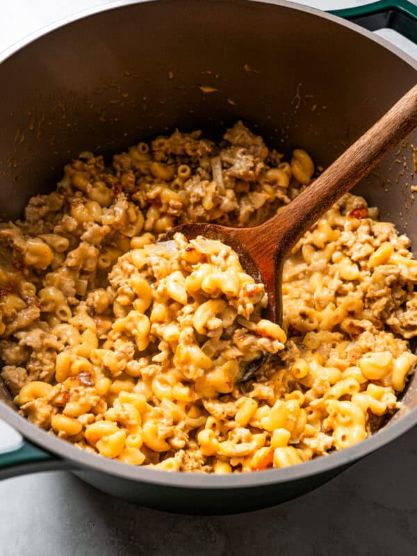 Hamburger Helper in a large pot with a wooden spoon.