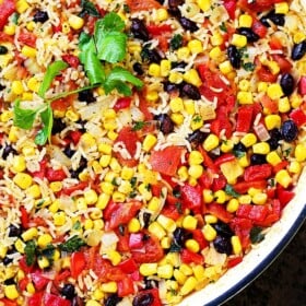 Fiesta Rice Recipe - Mexican inspired side dish recipe with fluffy, tender, flavorful rice and colorful veggies. Serve with Mexican food like, tacos or enchiladas, but it's just as good served with steak or chicken.
