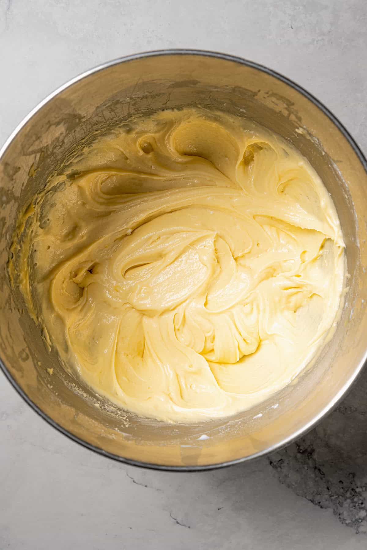 Vanilla cake batter in a metal mixing bowl.