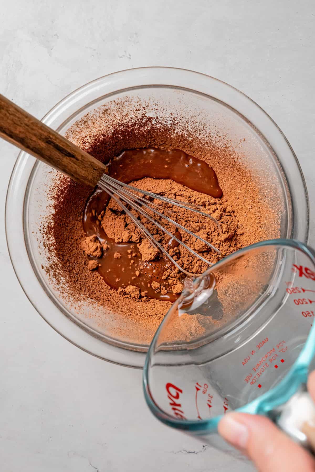 Hot water is poured into a bowl of cocoa powder.