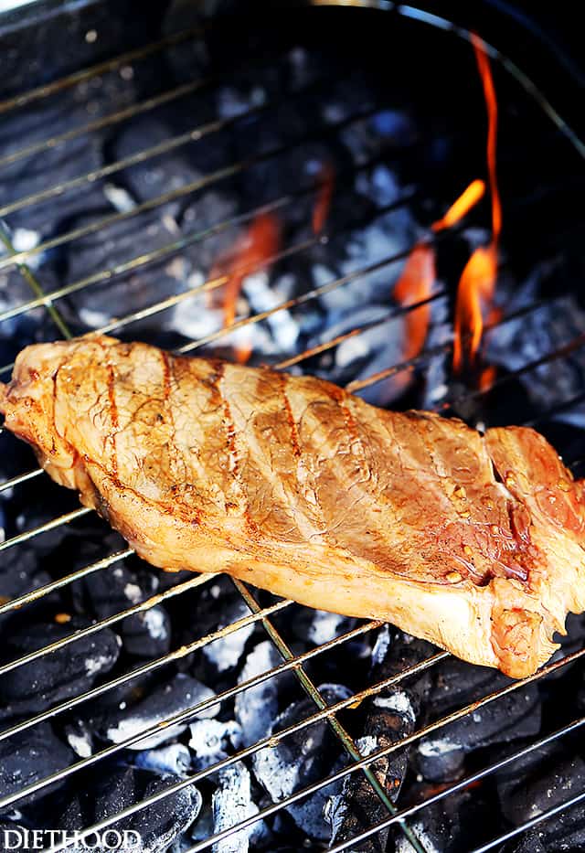 Steak cooking on hot grill grates.