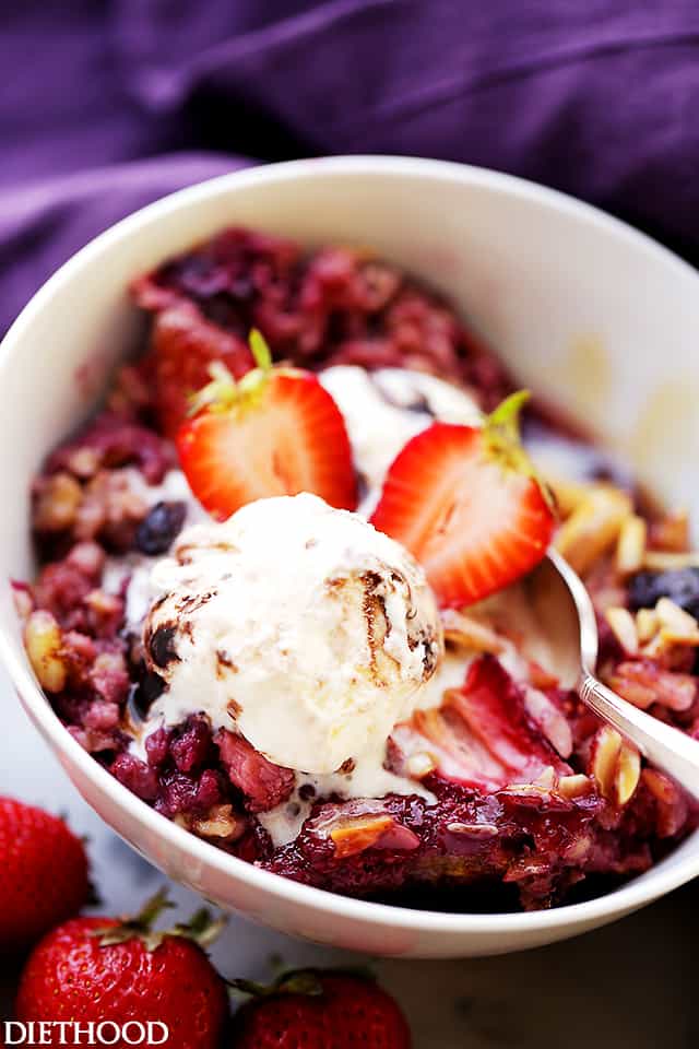 A serving of berry baked oatmeal in a bowl, topped with fresh strawberries.