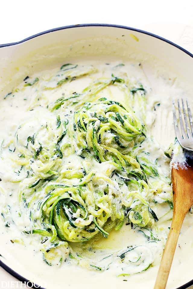 A skillet of zucchini noodles in a creamy sauce.