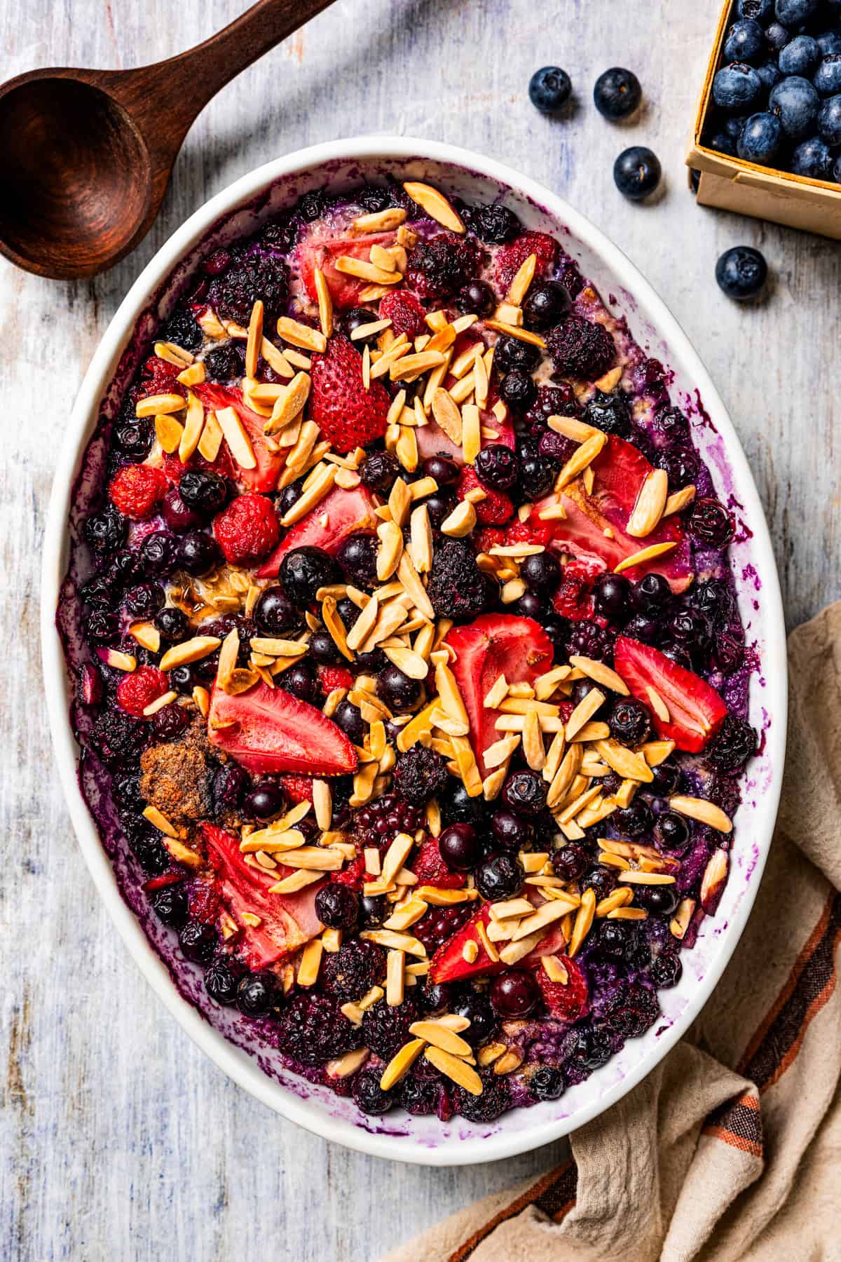 Assembled berry oatmeal in an oval casserole dish.