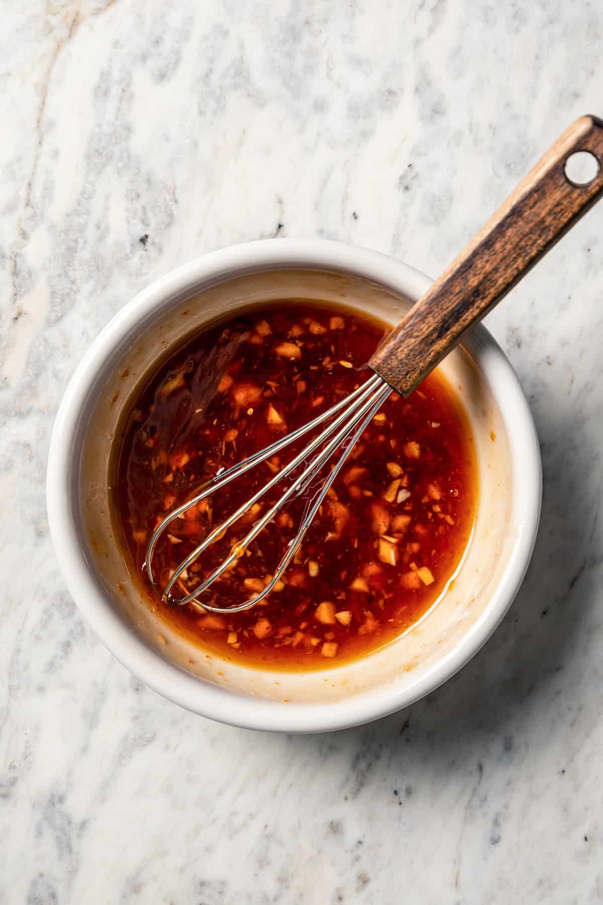 Citrus soy marinade in a bowl with a whisk.