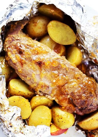 Grilled pork tenderloin inside of a foil pack with grilled baby potatoes