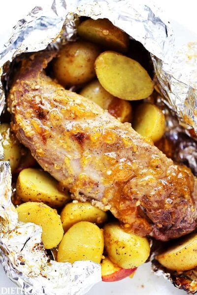 Grilled pork tenderloin inside of a foil pack with grilled baby potatoes