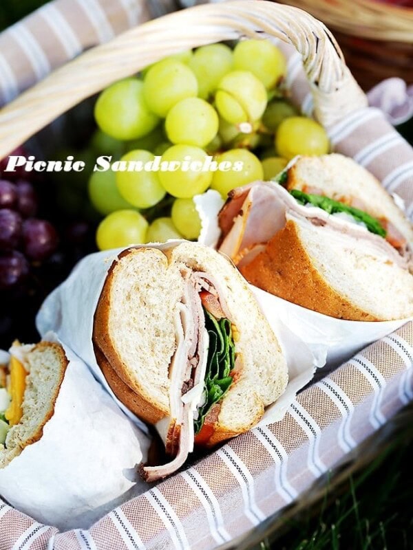 Labeled image of a picnic sandwich in a picnic basket with grapes.