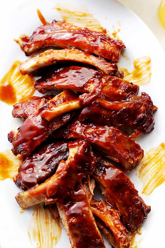 A White Plate Filled with Baby Back Ribs Smothered in Honey BBQ Sauce