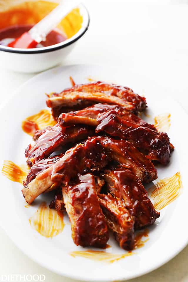 A Plate of Baby Back BBQ Ribs with a Small Bowl of BBQ Sauce in the Background