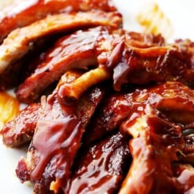 A Close-Up Shot of Freshly Made Barbecue Ribs Piled Up on a White Plate