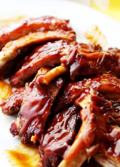 A Close-Up Shot of Freshly Made Barbecue Ribs Piled Up on a White Plate