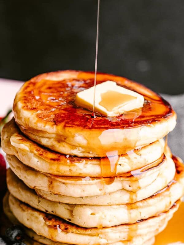 Pouring syrup over pancakes.