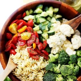 Potluck Pasta Salad with Dijon Vinaigrette - Quick and easy to make Potluck Pasta Salad packed with broccoli, tomatoes, cucumbers and cauliflower, all tossed in a zesty and delicious homemade Dijon Vinaigrette!