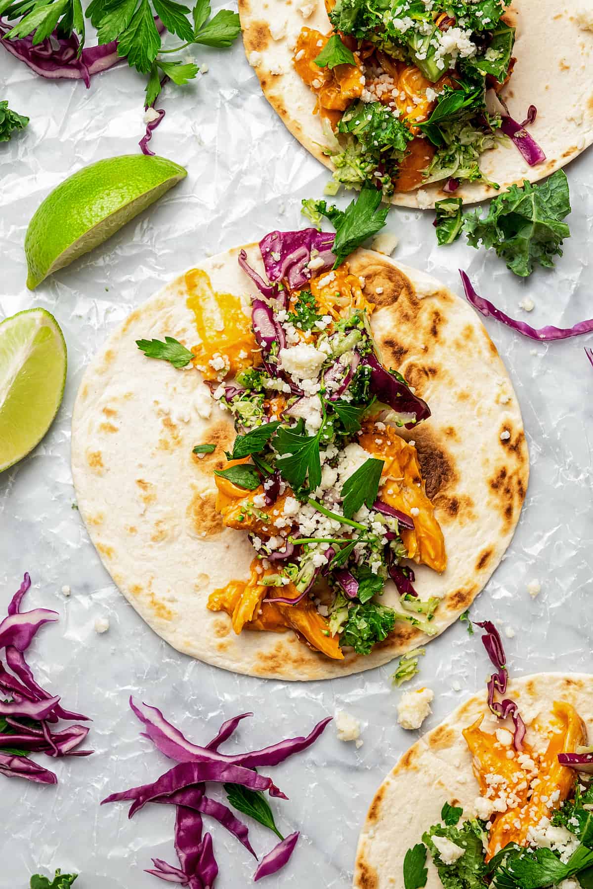 A tortilla with layers of chicken, broccoli slaw, and feta.