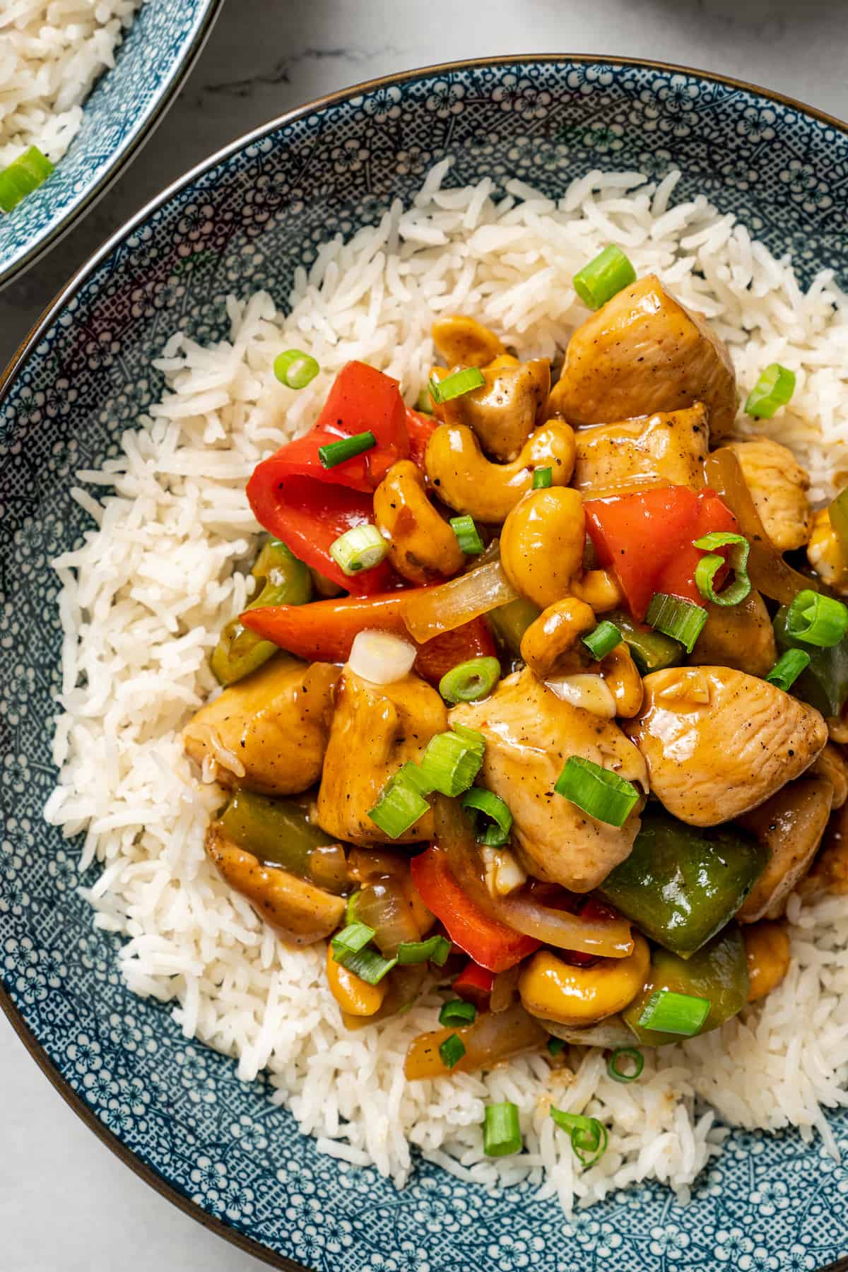 Close up overhead view of a plate of cashew chicken served on rice