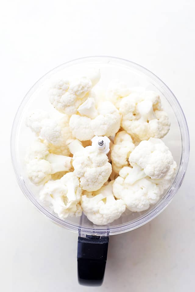 Cauliflower florets in the bowl of a food processor.