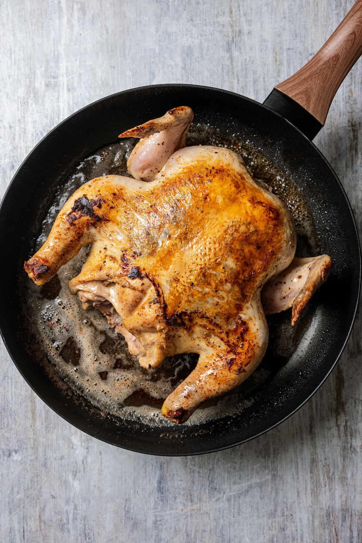 Crock pot honey lemon chicken is an easy dinner with a whole chicken slow-cooked in a citrusy honey lemon sauce with butter and seasonings. A whole seasoned chicken searing in a skillet with butter.