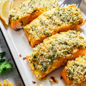 Honey mustard salmon fillets crusted with panko breadcrumbs on a baking sheet.