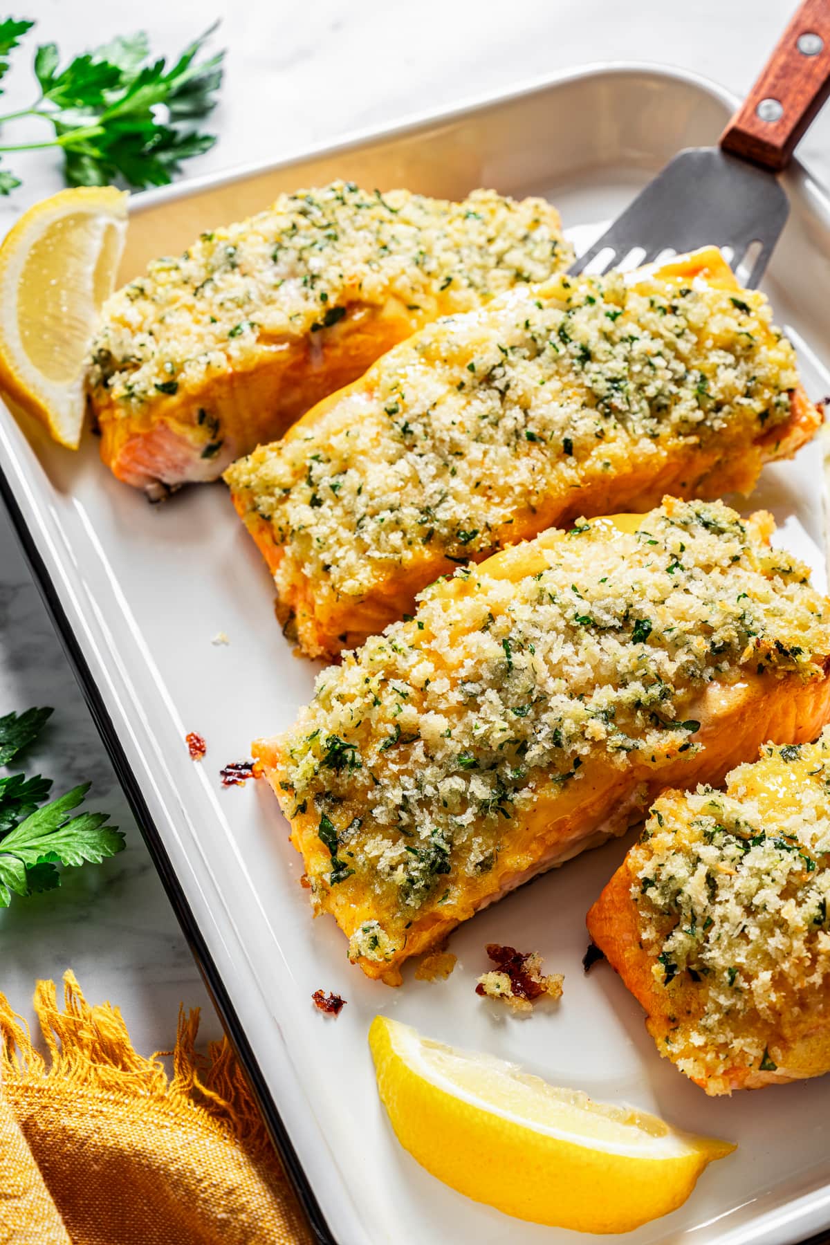 Honey mustard salmon fillets crusted with panko breadcrumbs on a baking sheet.