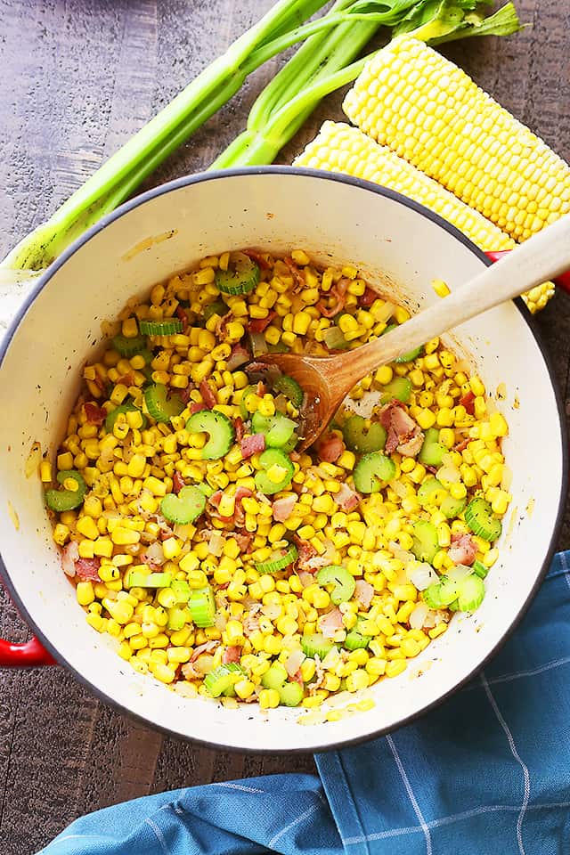 Frying corn, celery, and bacon in a Dutch oven.