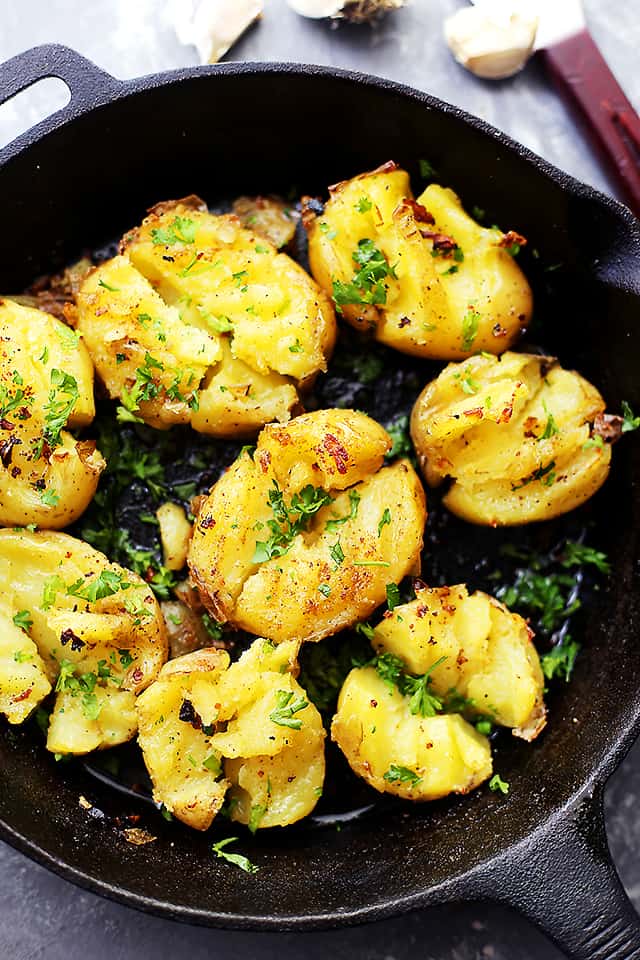 Overhead view of seasoned Smashed Potatoes in a cast iron skillet