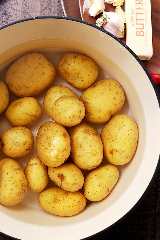 Raw yellow potatoes in a pot of water