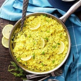Lemon Rice served in a skillet, with a spoon mixing through it.