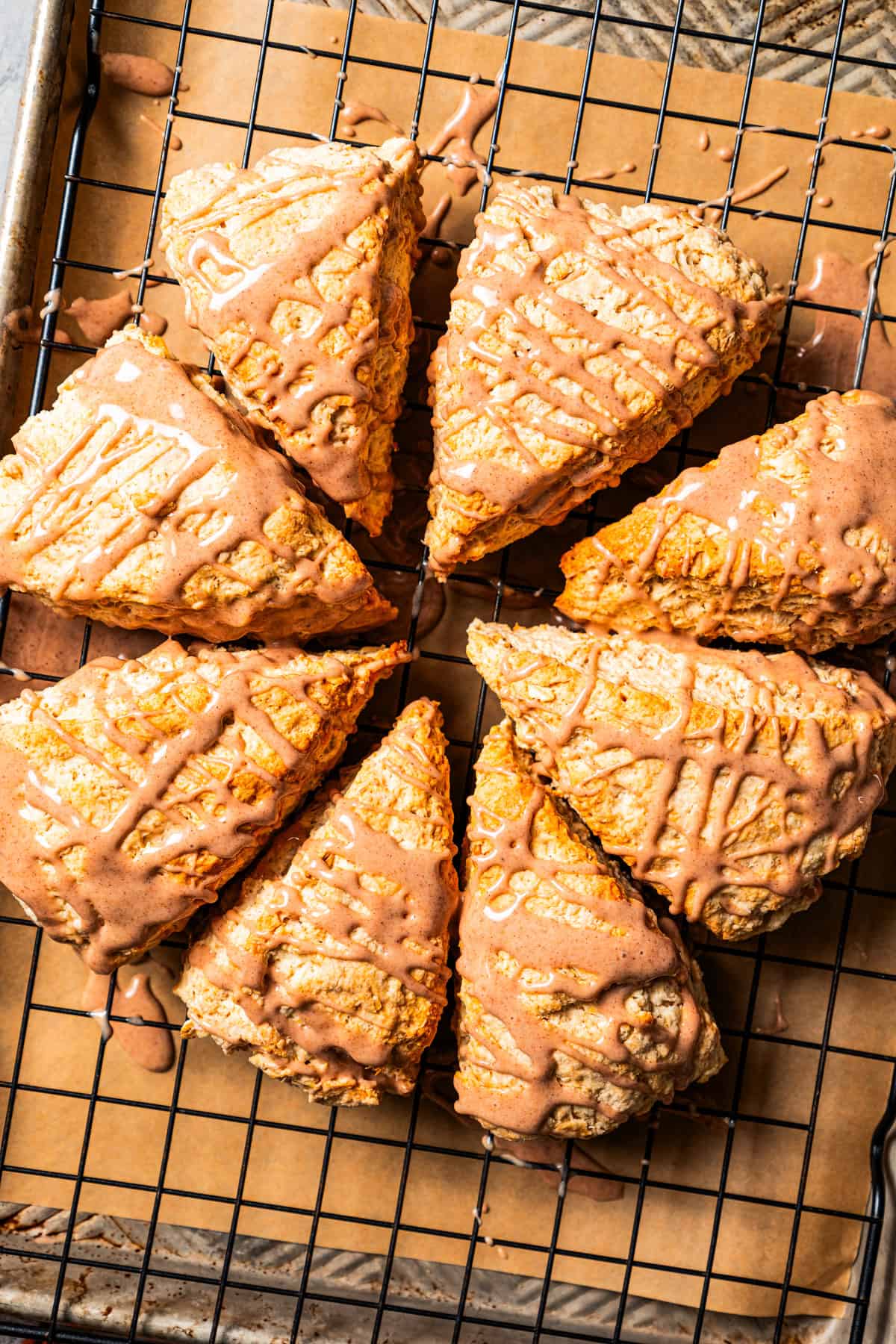 Baked and glazed cinnamon scones on a wire rack.