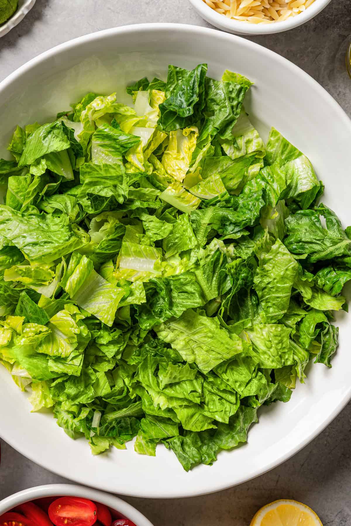 Chopped romaine lettuce greens in a large white bowl.
