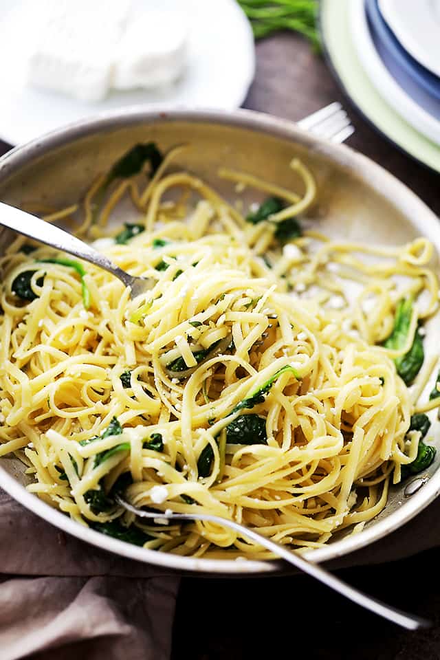 A fork twirling pasta in a skillet.