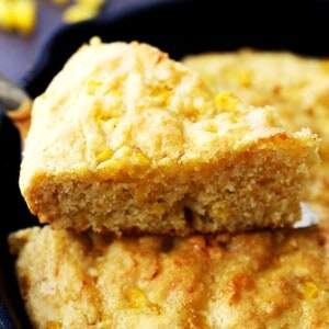 A slice of freshly baked cornbread coming away from the skillet