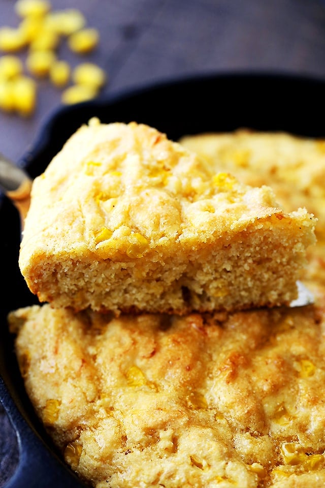 A slice of freshly baked cornbread coming away from the skillet
