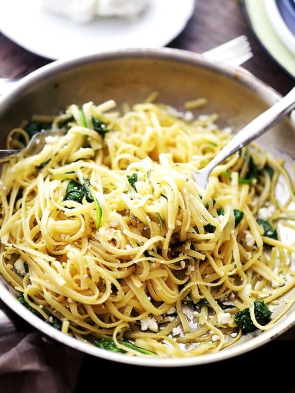 A fork twirling pasta in a skillet.