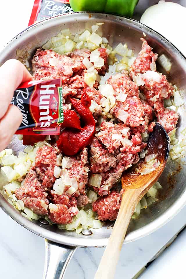 Sauteing diced onions and pork sausage in a skillet.