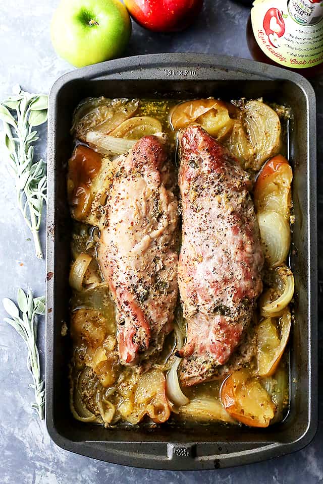 Apple Mustard Glazed Pork Tenderloin with apple and onion still in the roasting pan after being cooked