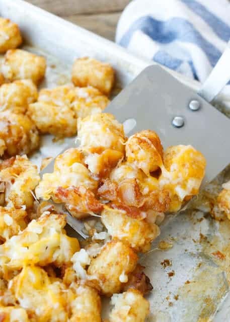Tater tots with bacon and cheese on a platter