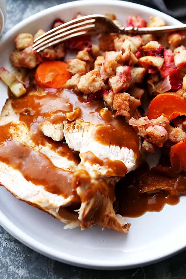 Honey-Soy Glazed Turkey Breast prepared in a slow cooker and served on a plate with stuffing and gravy.