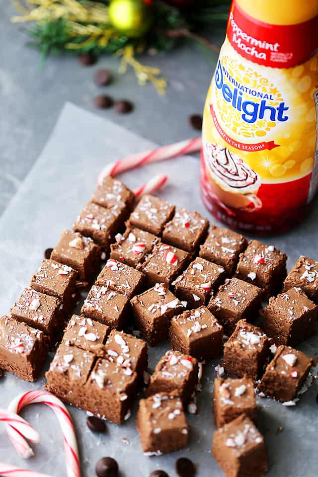 Peppermint Mocha Fudge cut into squares and set next to candy canes and a bottle of creamer.
