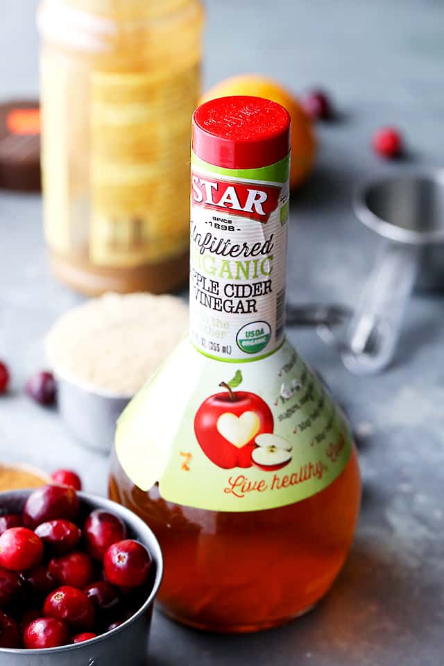 Ingredients for slow cooker cranberry sauce: fresh cranberries, apple cider vinegar, sugar, and orange juice.