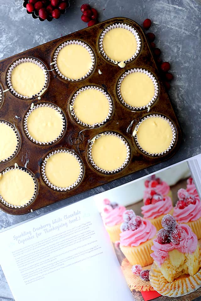 Sparkling Cranberry White Chocolate Cupcakes - Perfectly moist cupcakes filled with a creamy white chocolate ganache, and topped with a fresh cranberry frosting and sugared cranberries! 