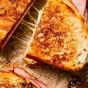 Close-up of grilled cheese sandwich cut in half to show the cheese pull.