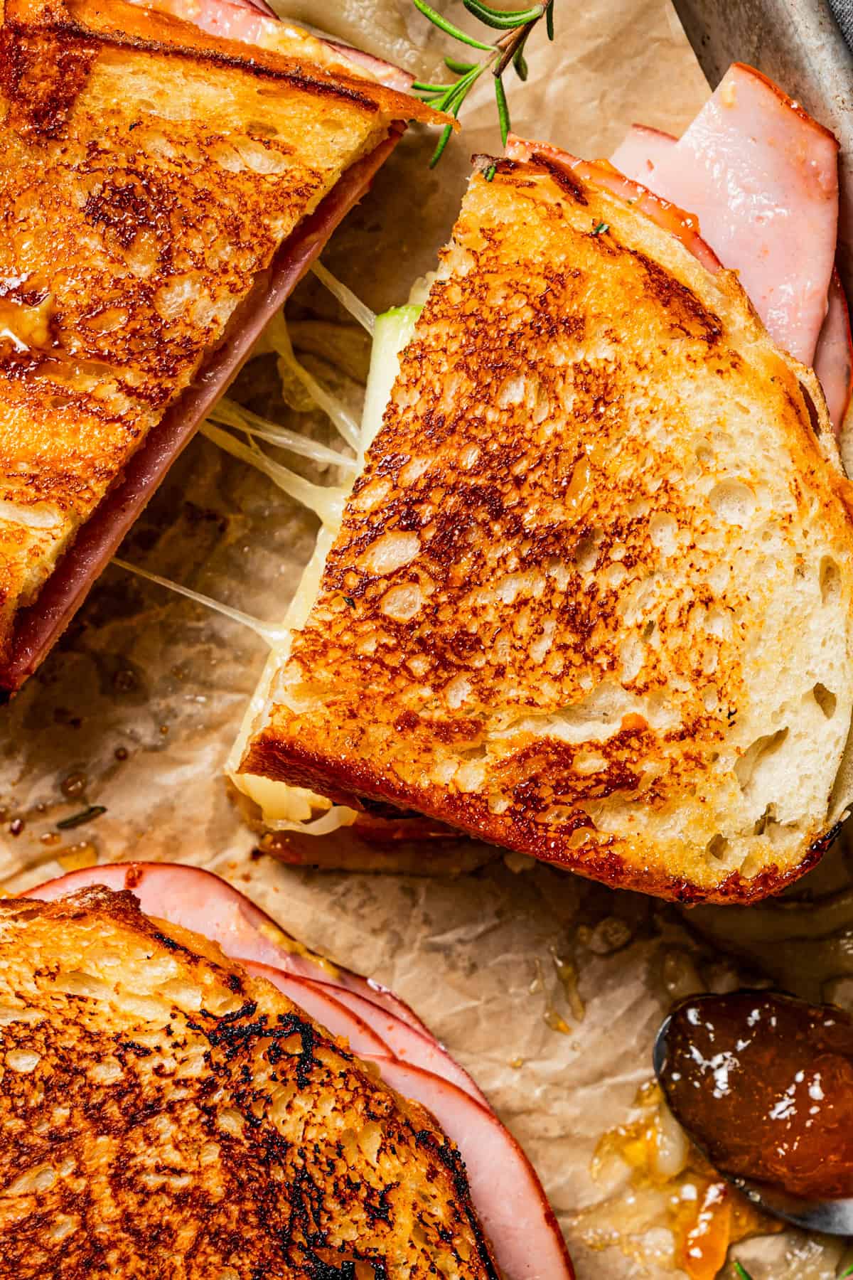 Close-up of grilled cheese sandwich cut in half to show the cheese pull.