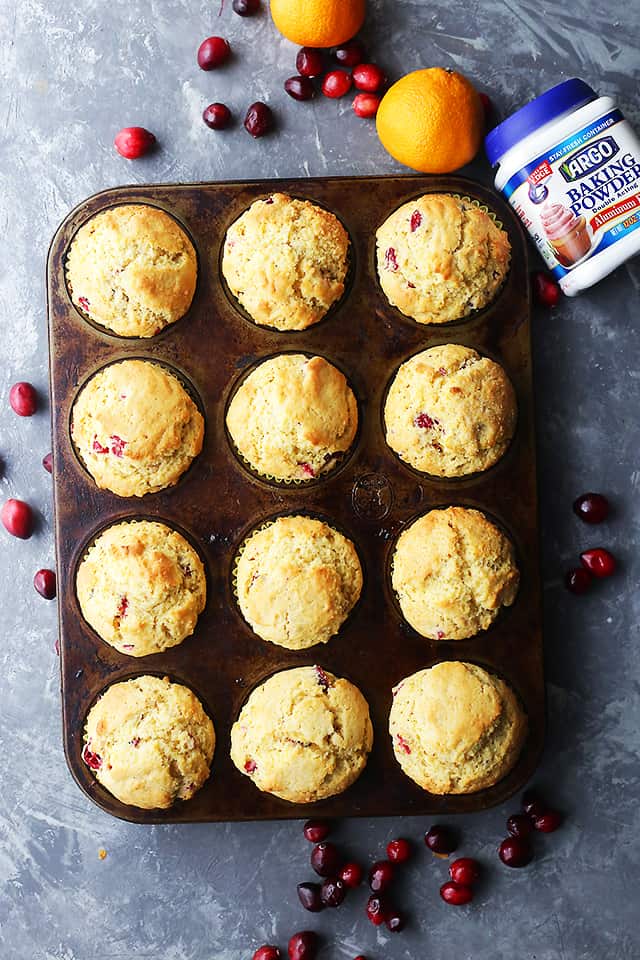Overhead image of baked Cranberry Orange Corn Muffins in a muffin tin.
